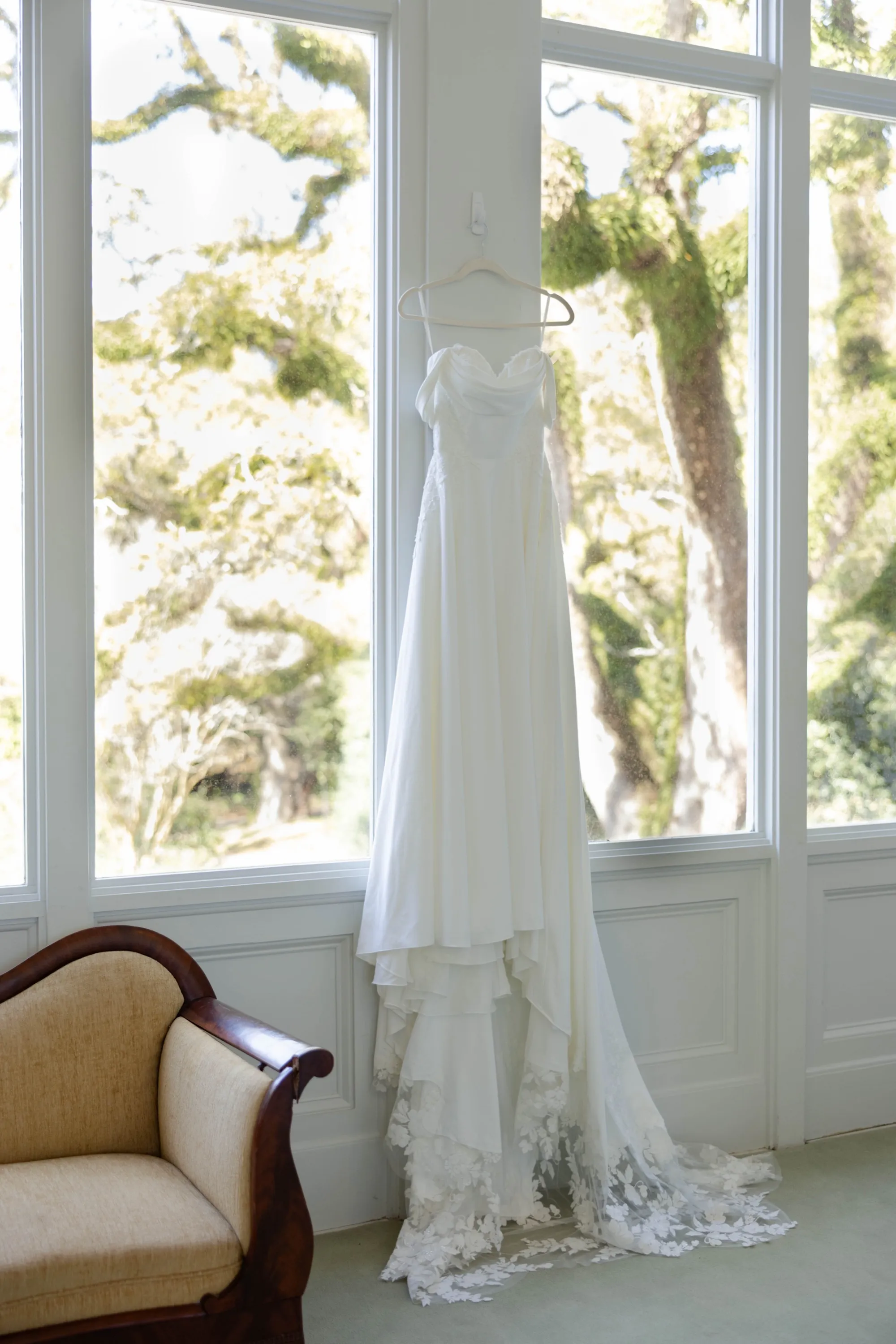 Hallie's lace-trimmed gown hanging in the mansion's tall windows