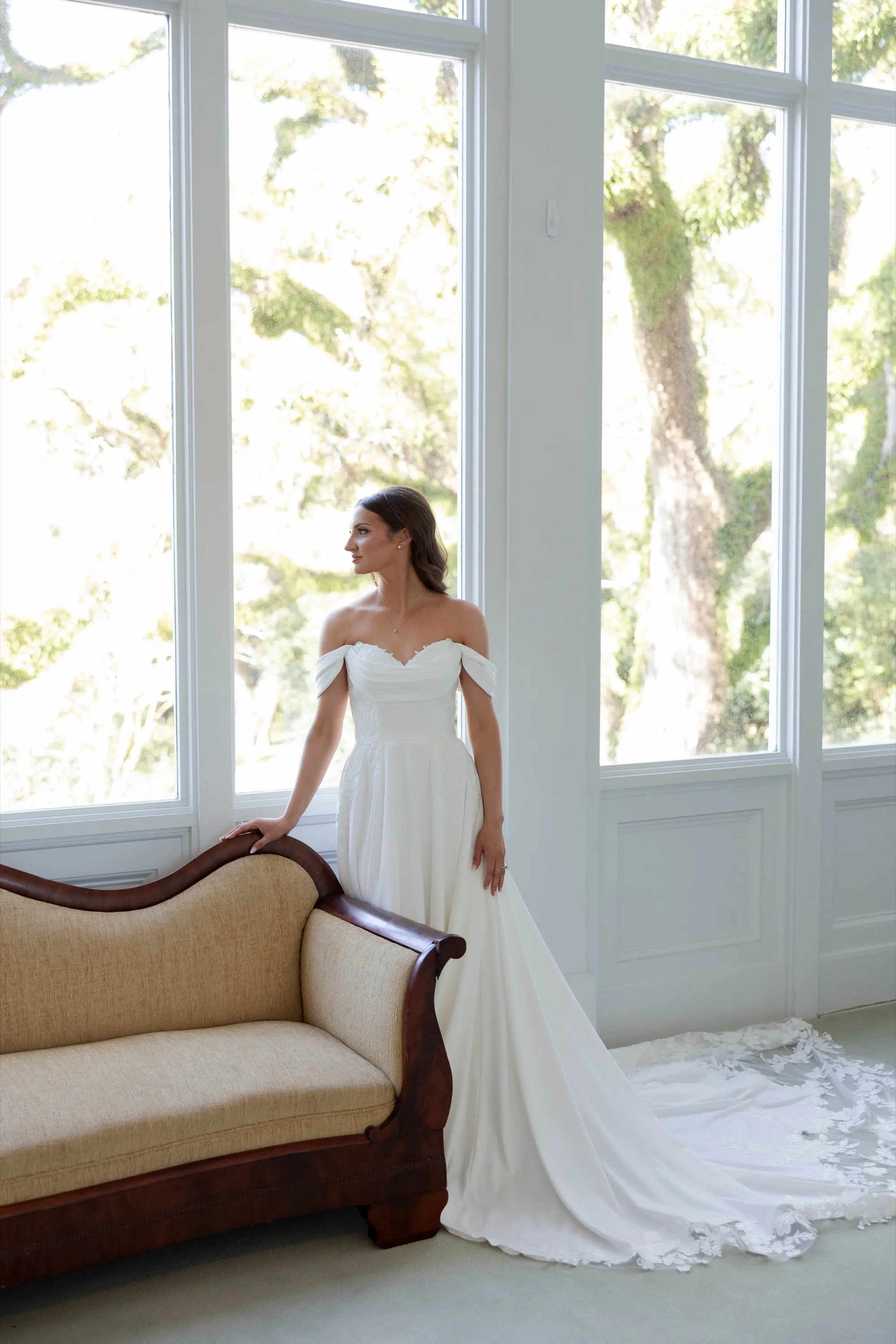Hallie in her off-the-shoulder gown beside the antique settee