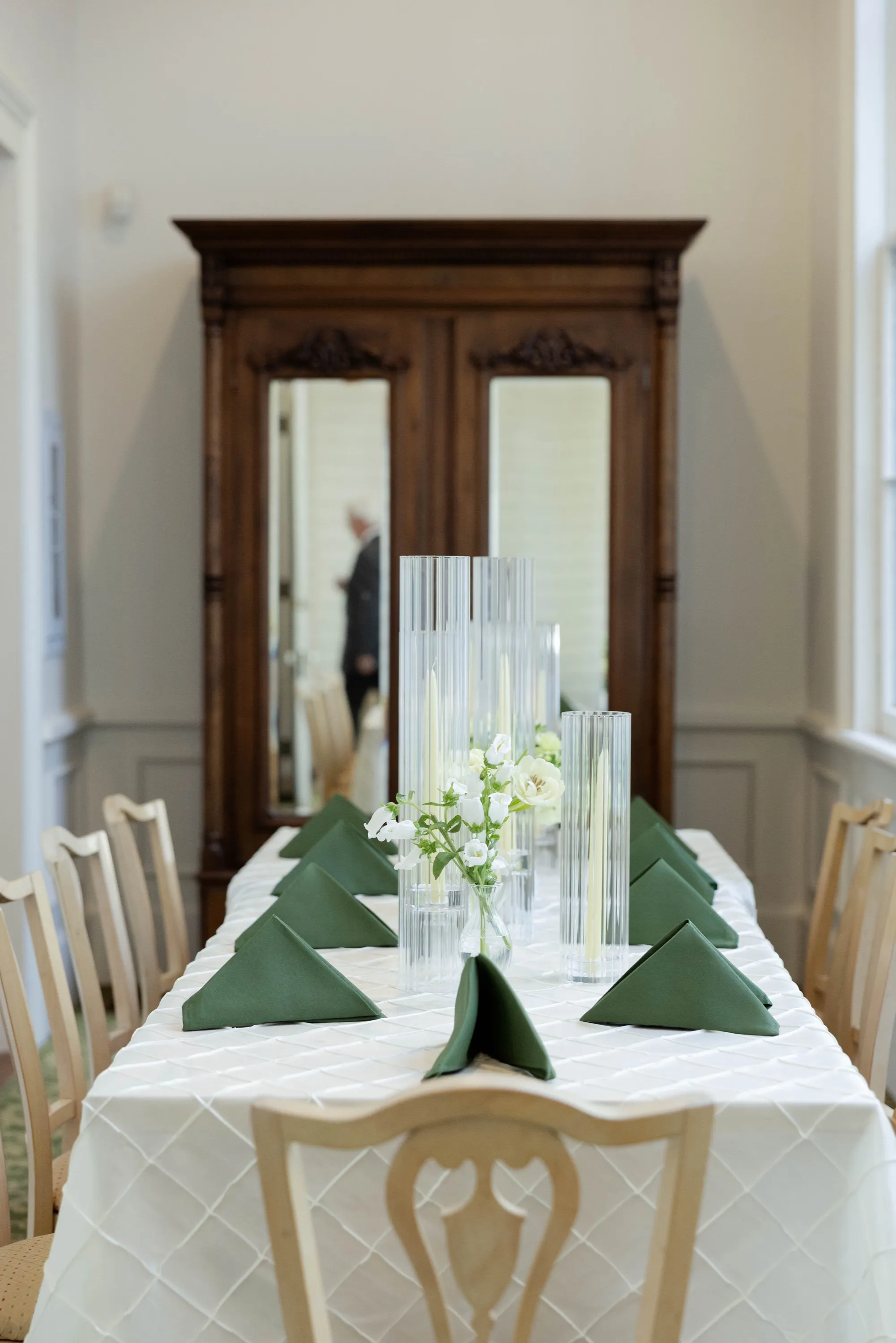 The head table — green napkins, taper candles, the old armoire behind