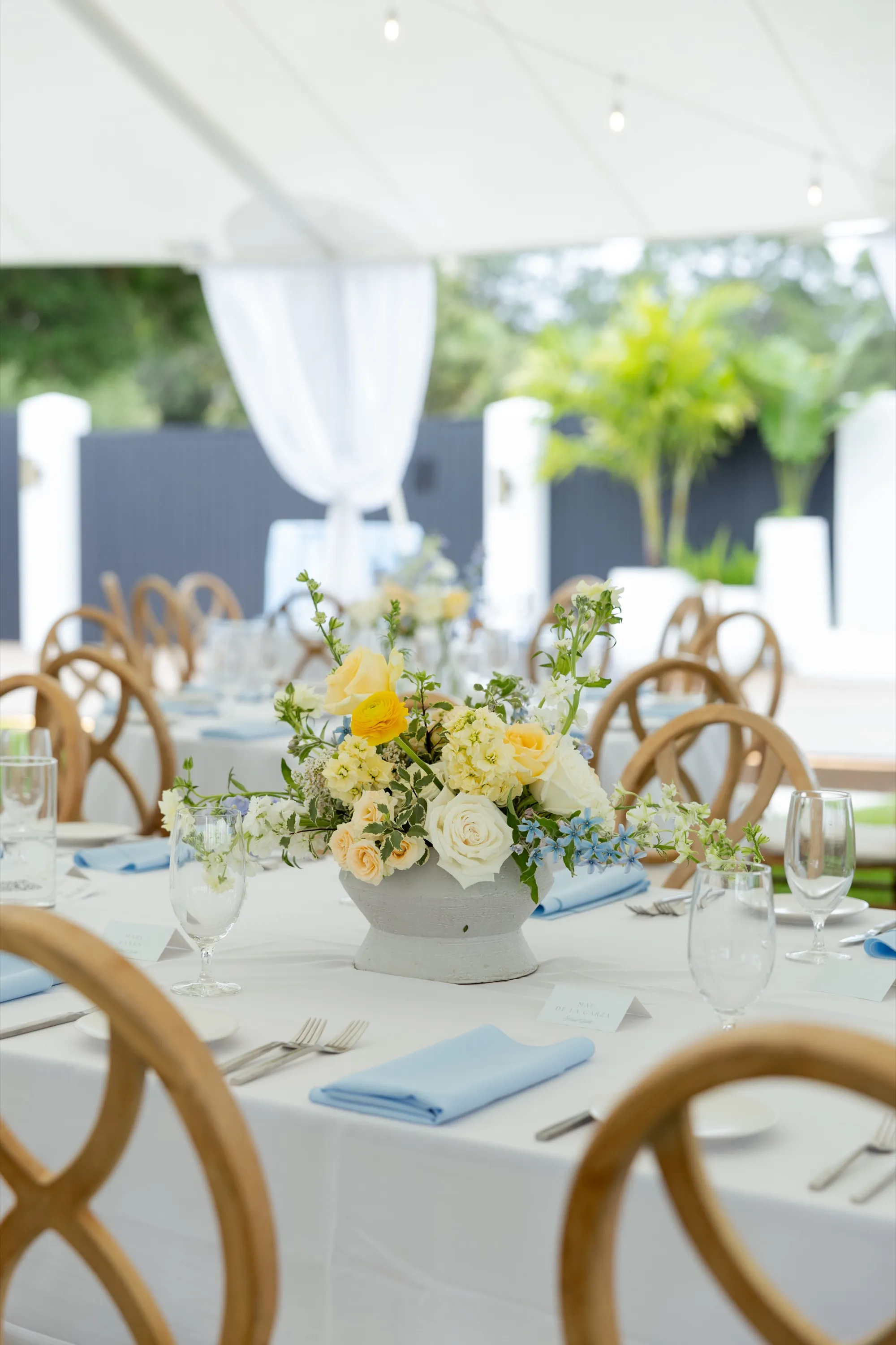 A centerpiece in yellow and blue under the sailcloth tent