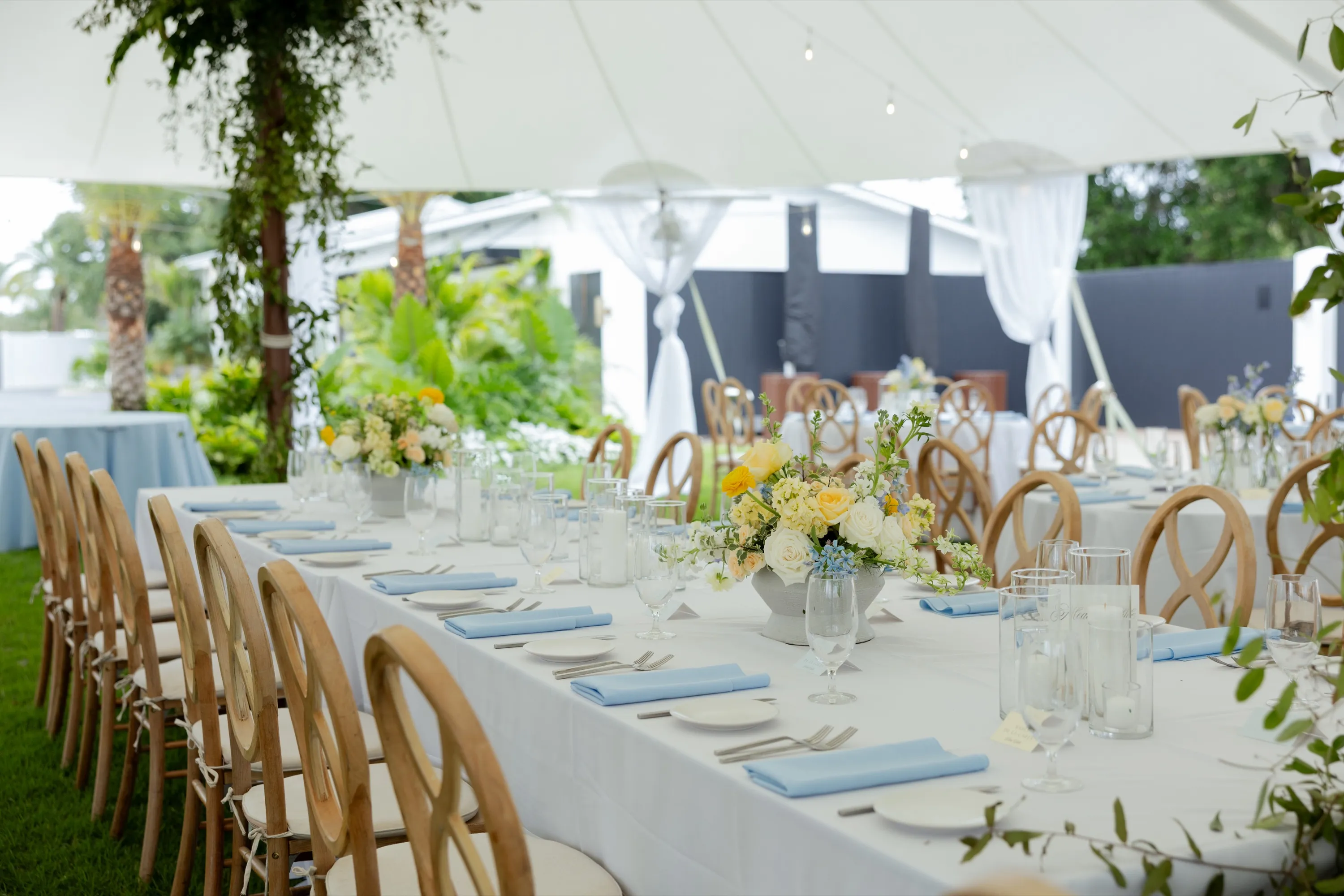 The long table set in pale blue under the tent
