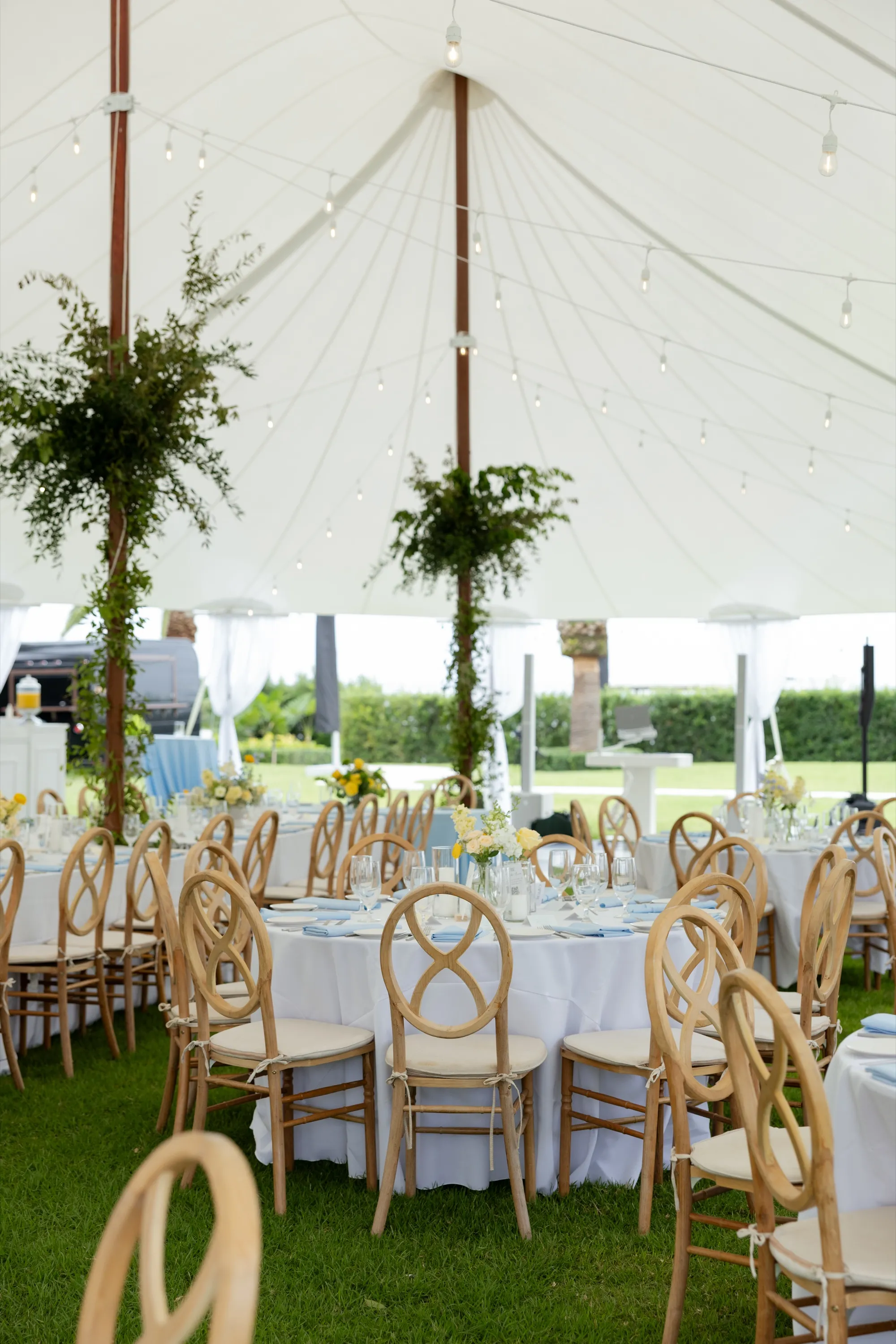 Round tables on the lawn under the sailcloth tent