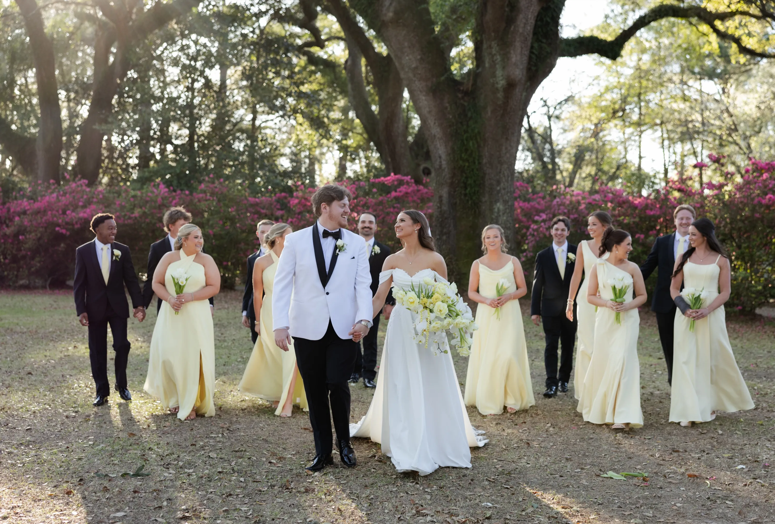 Hallie and JT lead the party across the grounds, yellow dresses behind