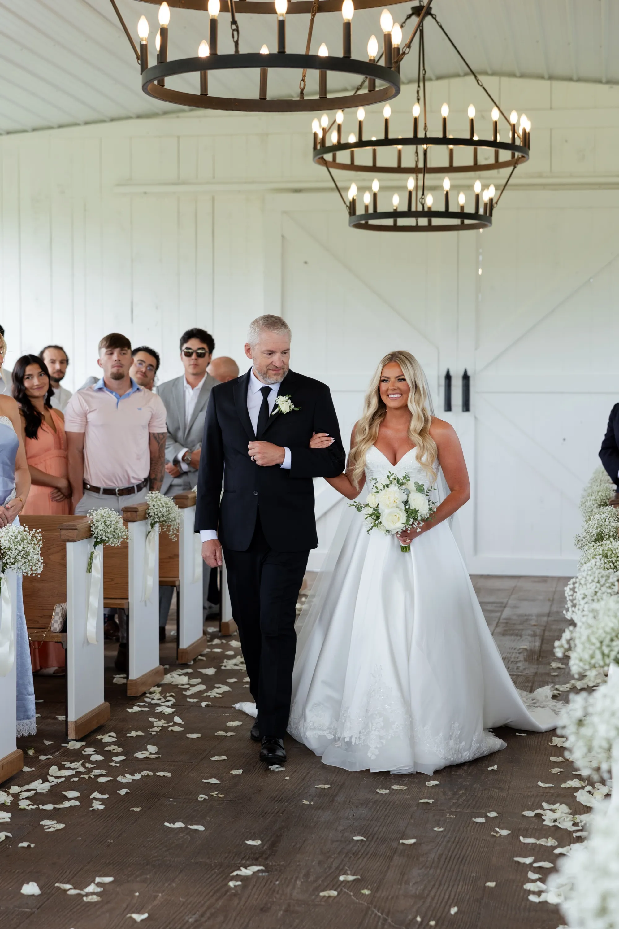 Taylor and her dad walk the petal-scattered aisle