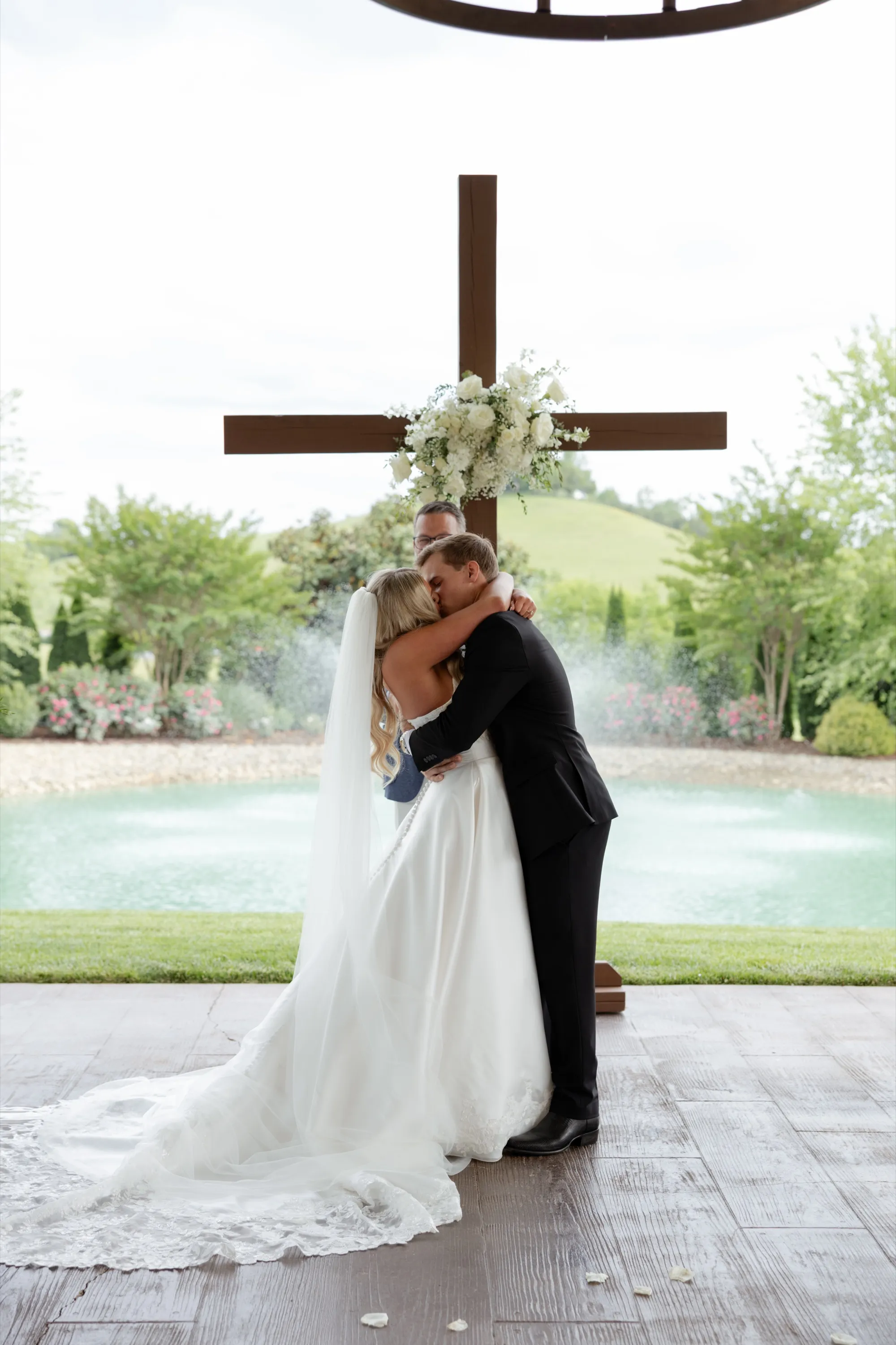 The first kiss at the altar beneath the wooden cross