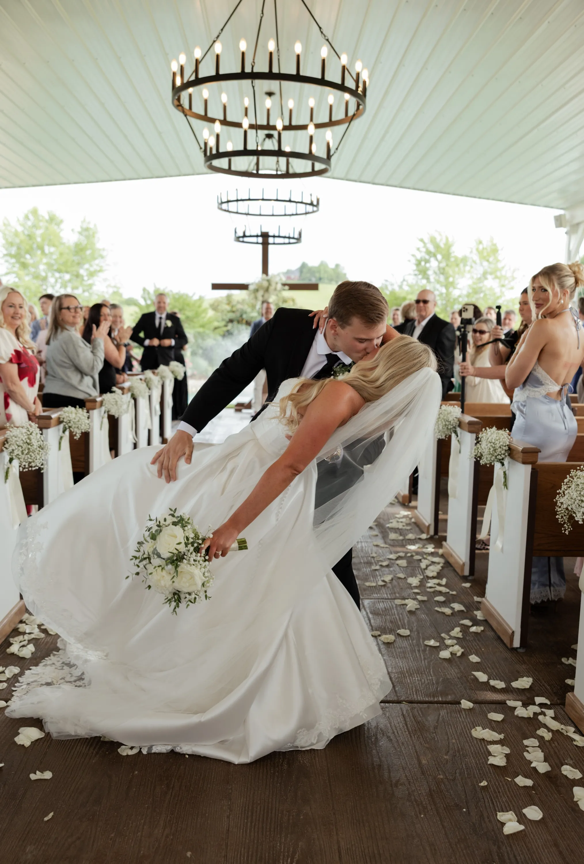 Andru dips Taylor on the way back up the aisle as guests cheer
