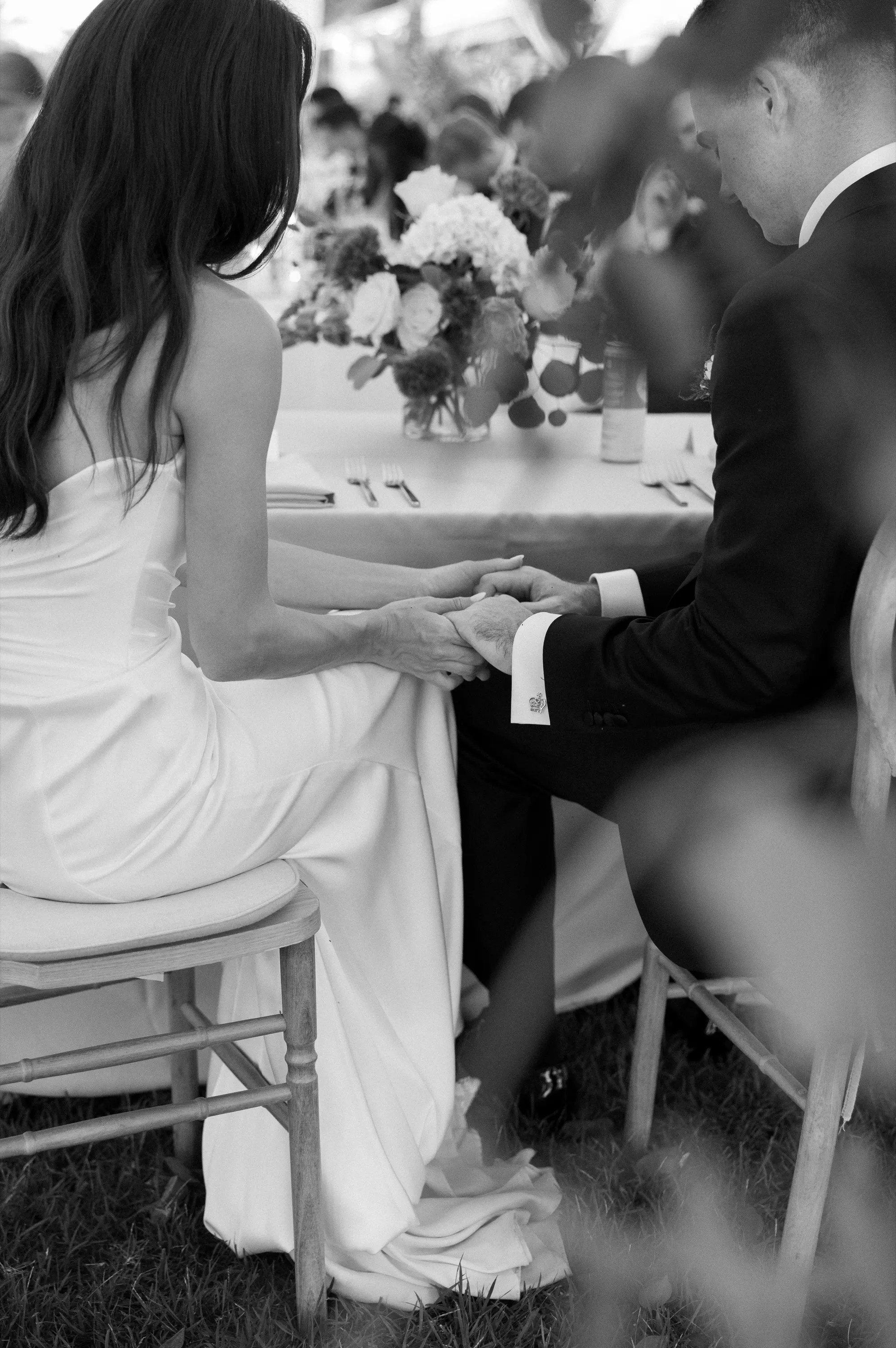 A quiet moment holding hands at the table, in black and white