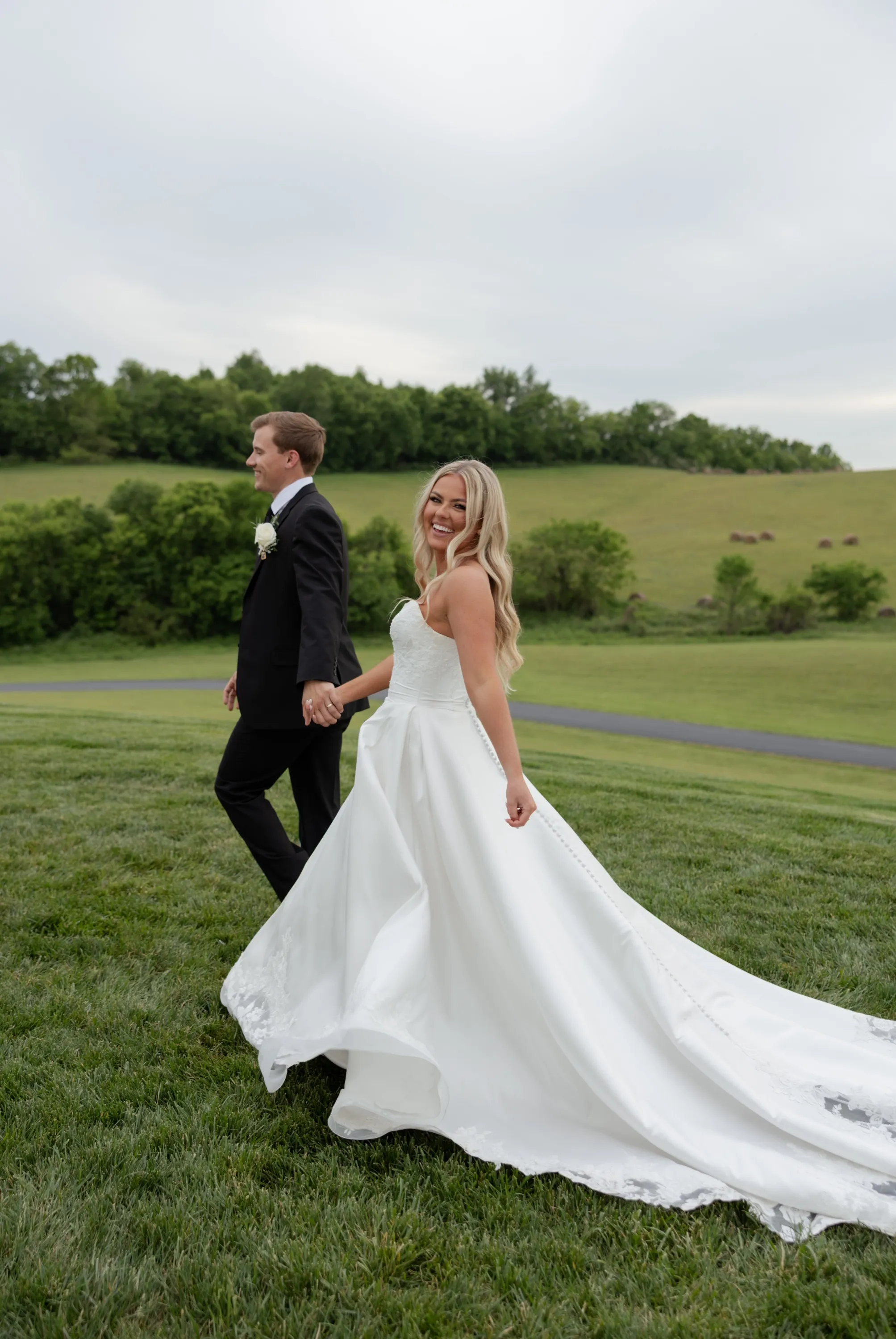 Walking the hill hand in hand, Taylor glancing back