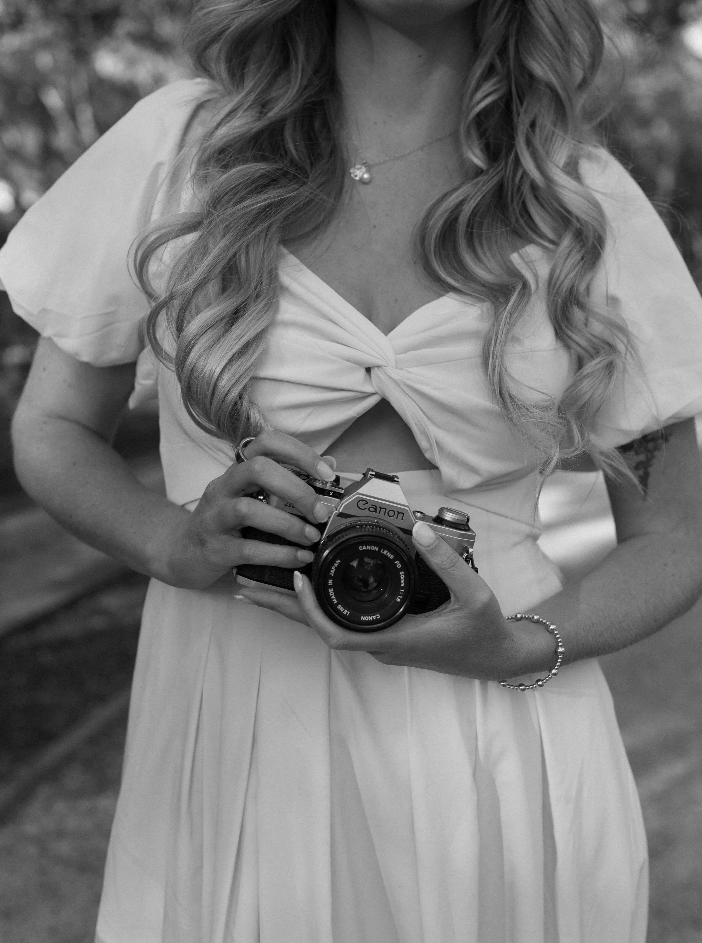 Brietyn holding her 35mm film camera, photographed in black and white