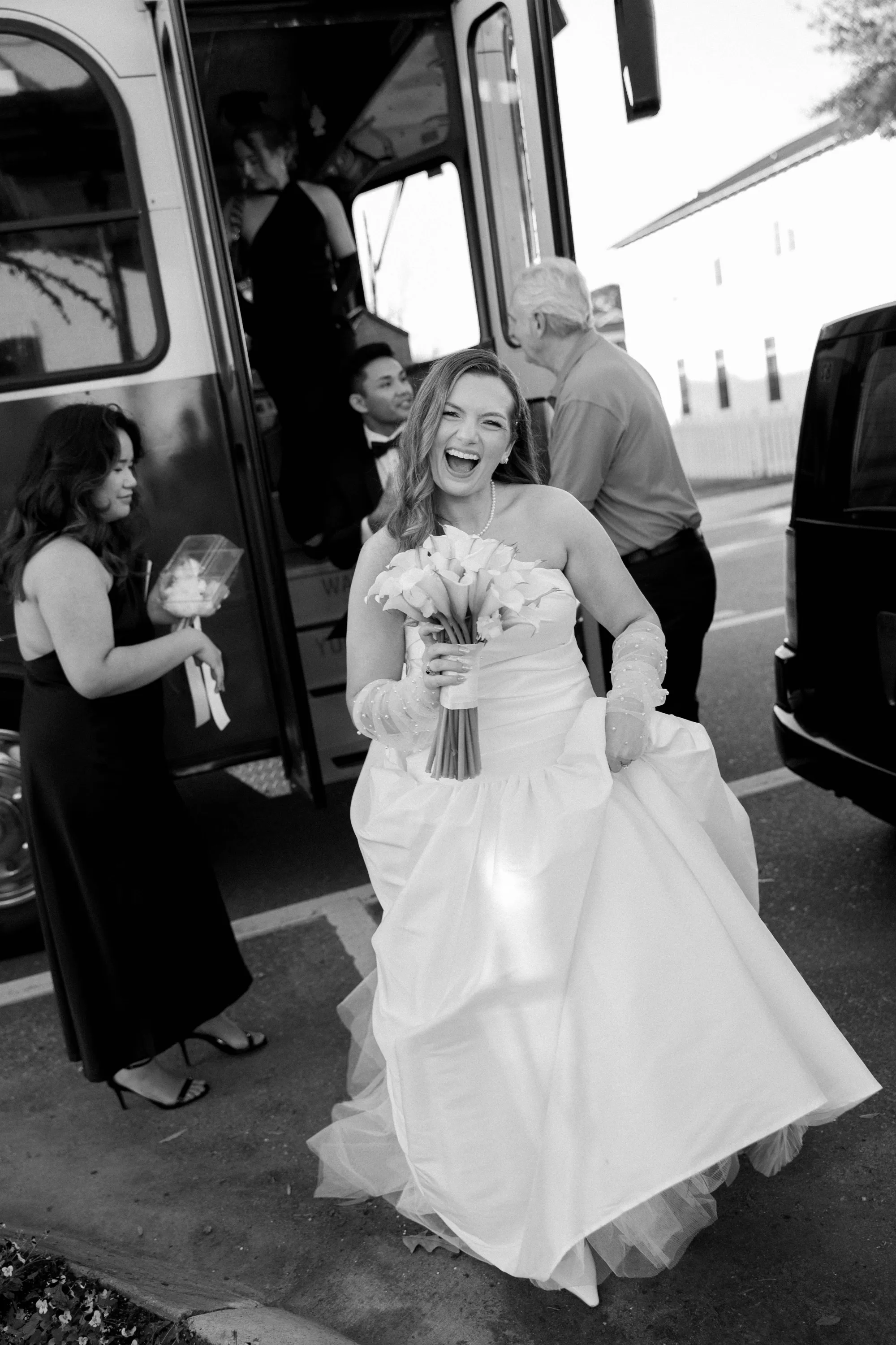 Lily laughing as she steps off the trolley, in black and white